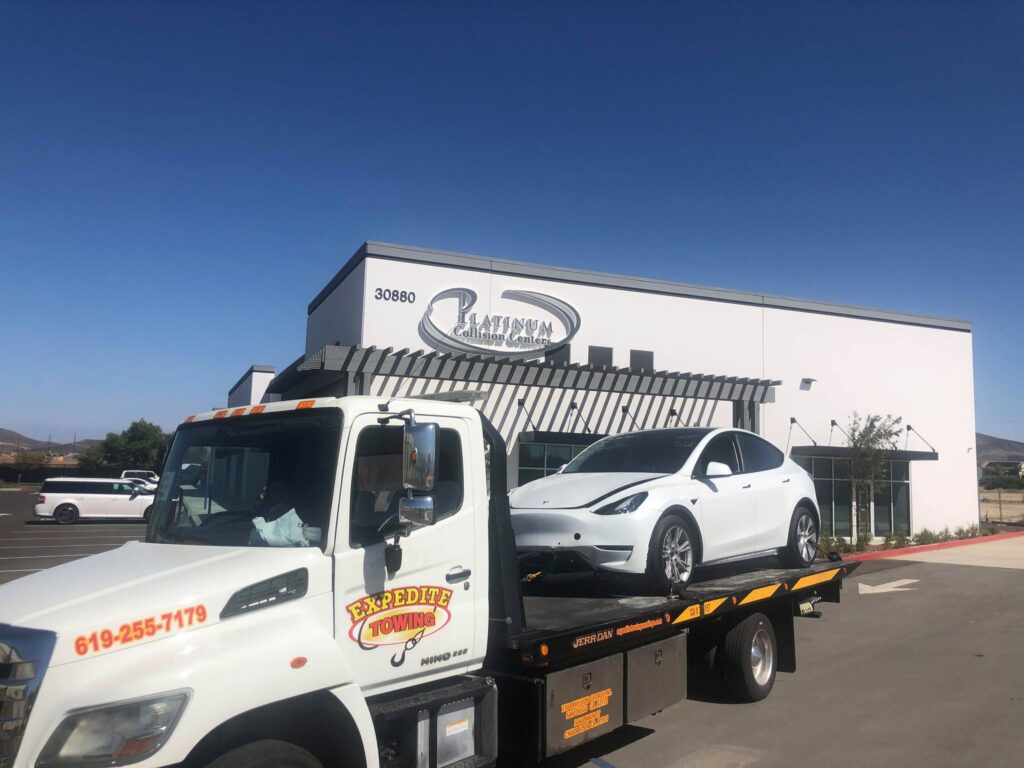 Tesla Car towed on flatbed tow truck in San Diego